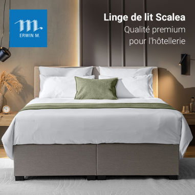 Linge de lit Scalea présenté sur un lit boxspring dans une chambre d’hôtel
